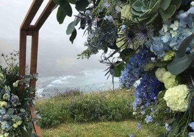 Floral arch with ocean view in the background.