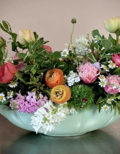 Colorful spring flowers in a green vase.