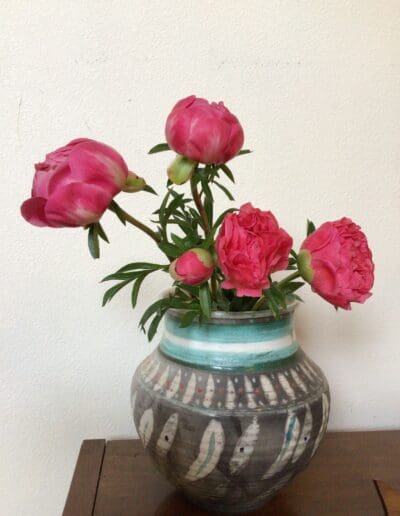 Pink peonies in a patterned vase.