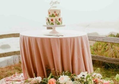 Floral wedding cake on a pink tablecloth.