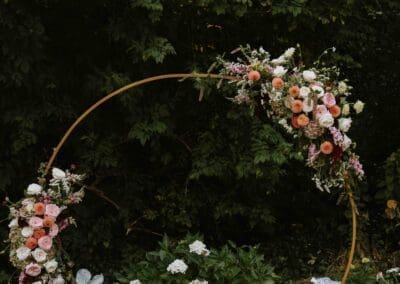 Gold arch decorated with pink flowers.