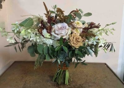 Rustic bridal bouquet with roses and greenery.