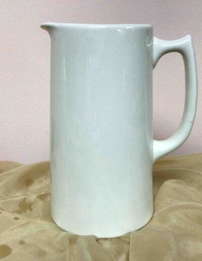 White ceramic pitcher on fabric.