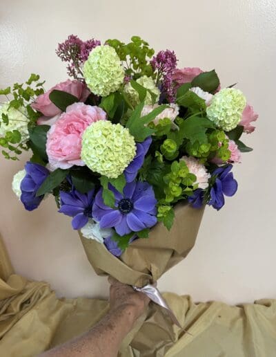 A bouquet of colorful flowers in brown paper.